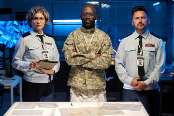 Aufkleber - Two mature officers in blue uniform and their young African American male colleague looking at camera in military command office