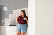 © ADDICTIVE STOCK - Curvy woman enjoys morning coffee while using smartphone in kitchen