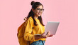 © Sergey - Young happy smart teen girl IT student she wear yellow casual clothes backpack bag hold use laptop pc computer isolated on plain pastel light pink background. High school university college concept,
