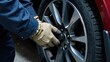 © Helga P-A. - A person wearing gloves is changing a car tire. Concept of: Automotive maintenance.