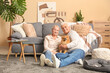 © Pixel-Shot - Happy senior couple with cute Pomeranian dog sitting on floor at home