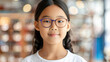 © ChimE - A joyful young girl tries on colorful glasses for the first time in an optician shop, embracing clarity with a smile.