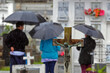 © cabuscaa - Families gathered in the rain on All Souls' Day in Porto Alegre, Brazil, honoring their loved ones in a cemetery