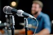 © Lens Legacy - A focused shot of a microphone with a musician subtly blurred in the background, conveying the essence of music creation, performance, and artistic passion.