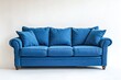 © Ruslan - A cozy blue three seater sofa rests on a white backdrop isolated against a white wall