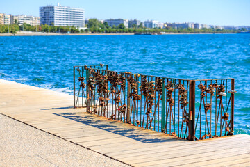 Wall Mural - A metal fence with flowers on it is next to a body of water