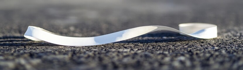 Aufkleber - Abstract silver ribbon curving on dark textured surface.