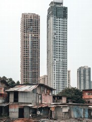 Aufkleber - Luxury skyscraper juxtaposed with rundown shacks in a contrasting urban landscape. Generative AI