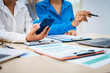 © R Photography - Close-up of three business people's hands during a meeting at an office table.They are engaged in discussions,planning,analyzing finance, investments, and market trends during a monthly team meeting