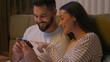 © Yuliia - Caucasian couple man woman boyfriend girlfriend together bed bedroom mobile phone smartphone gadget laughing smiling watching funny video technology enjoy humor browsing female male sweetheart spouses