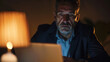 © KOSHKAROV SERGEI - Focused Businessman Working Late on Laptop