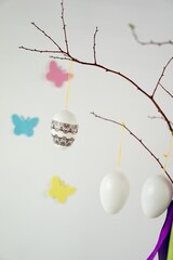 Wall Mural - Easter eggs hanging on twig with ribbons