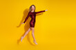 © deagreez - Fashionable woman in red sequined dress celebrating against vibrant yellow background, stylish and glamorous