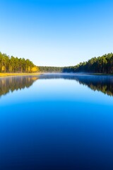 Poster - Calm lake reflecting autumn trees and clear blue sky.