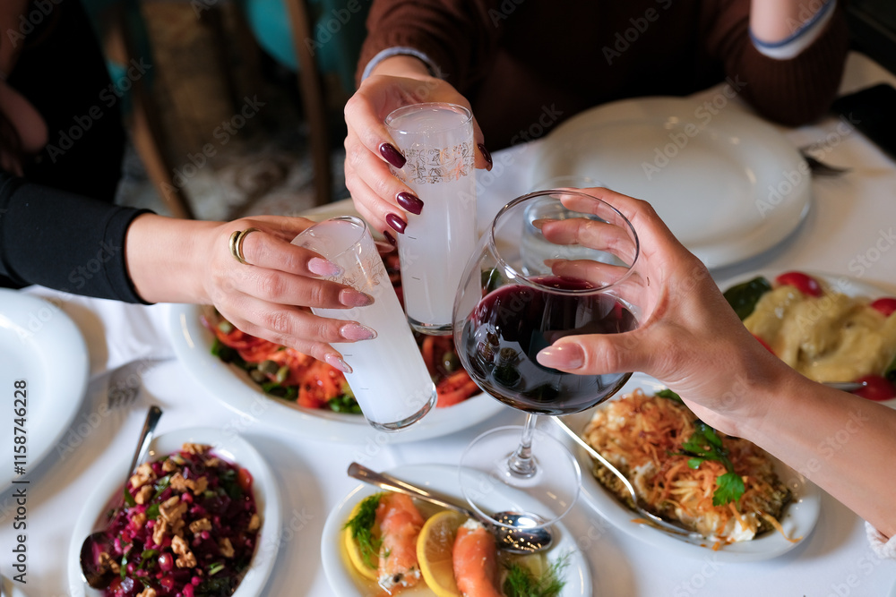 Woman Hands Toasting with Raki and Wine at a Dinner Table. A ...