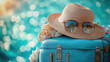 © Kashem - Blue suitcase with hat, seashell, sunglasses, and beach towel against bokeh sky for travel banner