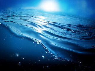 Poster - Sunlit ocean surface meeting deep blue water, with gentle waves and air bubbles rising.  A tranquil underwater scene.