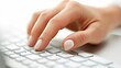 © NEW STUDIO - Female office worker typing on white keyboard, close up on hand