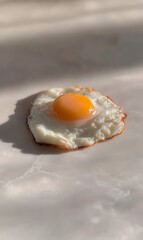 Canvas Print - Single fried egg with yolk on beige surface.