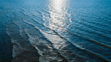 Poster - top view of Ocean blue and calm with sun rays reflection on smooth waves as textured blue background for banner template or web page design. Water calm with smooth waves.