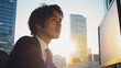 © bephoto - 朝日が差し込むオフィスで市場を分析する日本人男性ファイナンシャルアナリスト