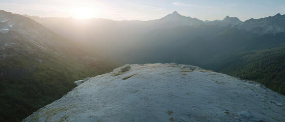 Wall Mural - Serene mountain landscape at sunrise, showcasing vast valleys and peaks bathed in soft light.