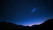 © Milon - Stars illuminate a dark sky over mountain silhouettes at dusk