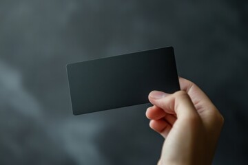 Leinwandbilder - Hand holding a sleek black gift card ready for personal expression and creative design opportunities in vertical space. Generative AI
