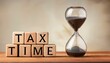 © photostockatinat - Tax Time Deadline: Wooden blocks spelling out 'Tax Time' sit beside an hourglass, symbolizing the urgency and limited time for tax filing.