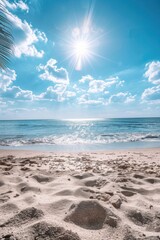 Wall Mural - Beach with a clear blue sky and a sun shining on the water. The sun is reflecting off the water, creating a beautiful and serene atmosphere