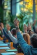 © Georgii - Group of people raising hands in a collaborative meeting setting