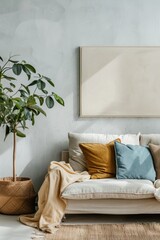 Wall Mural - Living room with a white couch, a plant, and a framed picture. The couch is covered with pillows, and there is a basket on the floor. The room has a cozy and welcoming atmosphere