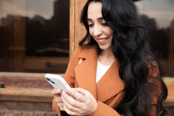 Sticker - woman in a coat with a smartphone