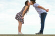 © Voyagerix - Couple flirting kissing on date against sky background