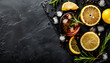 © Oleksiy - Alcoholic drink with lemon, rosemary and ice on rustic black stone table, copy space, top view. Cold drink with lemon