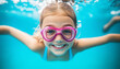 © The - A smiling girl with pink swimming goggles enjoys an underwater view in a bright blue pool. Summer fun and carefree underwater adventure.