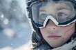 © vefimov - Young child wearing snow skis and goggles, looking towards camera in a winter setting.