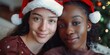 © vefimov - Two women wearing Santa hats smiling at the camera, capturing a festive holiday moment.