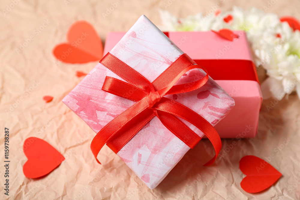 Gift boxes with white chrysanthemum flowers and hearts on crumpled paper. Valentine's Day celebration