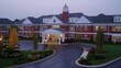 © shikatso - Elegant brick assisted living facility at dawn.