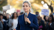 © Silga - Professional woman speaks to crowd during a protest gathering in a public park