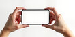 © Maryna - Hands hold blank smartphone screen. Horizontal orientation. Modern device. Empty screen. Tech mockup. Display template for video. Potential ad concept. New phone model. Isolated white background.