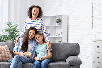 Wall Mural - Mature woman hugging her daughters with gifts at home