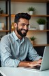 © Maryna - Smiling Indian man works on laptop in home office. Likely business executive entrepreneur. Happy young Indian student remote studies attends virtual class. Tech scene of remote work, education.