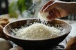 © NASH - Shredded young coconut added to bowl for preparing Es Kelapa Muda for Ramadan breakfast