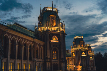 Illuminated Gothic palace towers under dramatic evening sky