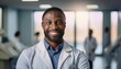 © Nelson - Portrait of smiling african american doctor wearing white coat in hospital corridor