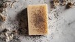 © 2rogan - Homemade brown soap bar with poppy seeds on marble surface surrounded by dried flowers promoting self care and sustainability in lifestyle
