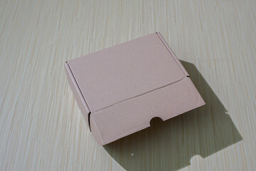 A brown paper box isolated on a table, perfect for packaging or gifting, offering a simple and eco friendly design and mockup