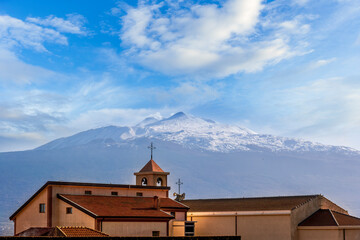 Wall Mural - scenic view from a beautiful italian town to amazing buildings with church and roofs and picturesque highland mountain with nice blue cloudy sky on background